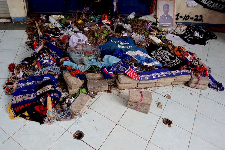 Tumpukan taburan bunga dan atribut Aremania 5 bulan pasca Tragedi Kanjuruhan 1 Oktober lalu yang menelan 135 korban jiwa dan 500an korban luka-luka akibat gas air mata usai pertandingan pekan ke-11 Liga 1 2022-2023 yang berakhir dengan skor 2-3 di Gate 12 Stadion Kanjuruhan Kepanjen Kabupaten Malang, Senin (1/3/2023) siang.