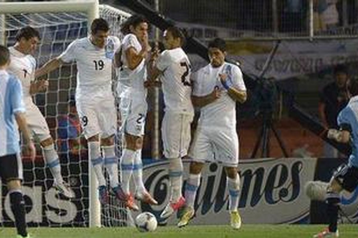 Tendangan bebas Lionel Messi mengecoh pagar betis Uruguay sebelum merobek jala Fernando Muslera. Argentina menang 3-0 atas Uruguay, Jumat (12/10/2012).