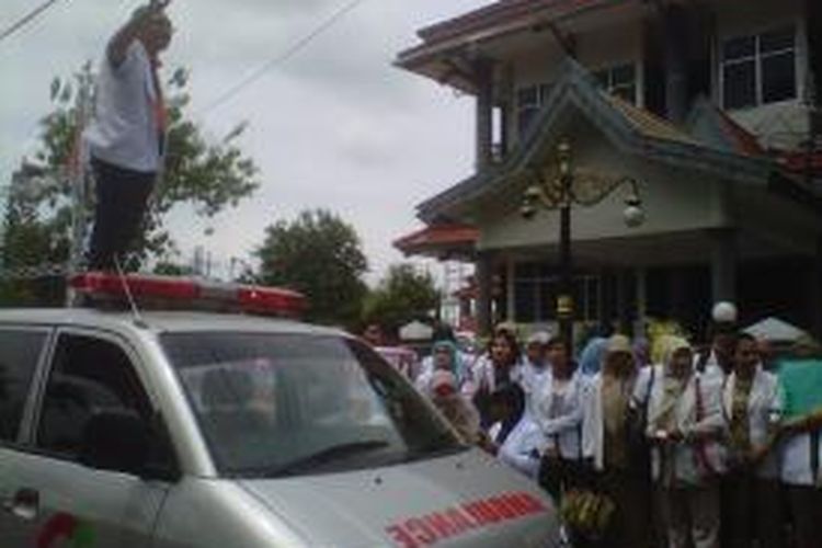 Seorang dokter di Situbondo berorasi di atas ambulans saat berdemonstrasi di depan kantor DPRD Situbondo, Rabu (27/11/2013). 