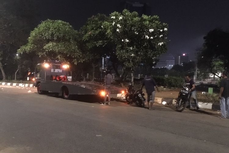Mobil derek dari Polda Metro Jaya mengangkut sepeda motor yang ditinggalkan para peserta demo mahasiswa pada Selasa (24/9/2019). Gambar diambil pada Rabu (25/9/2019) dini hari.