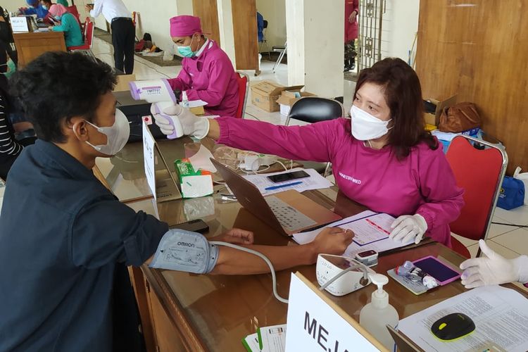 Dokter sedang memeriksa kesehatan dari calon penerima vaksin di lokasi vaksinasi