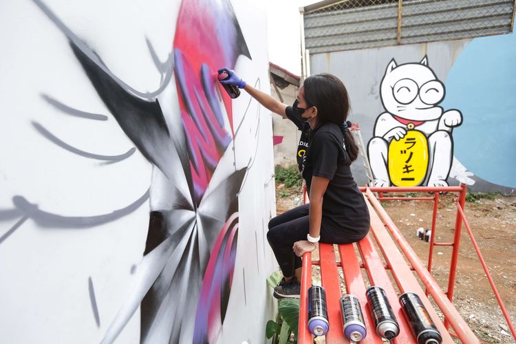 Seniman jalanan Bunga Fatia menyelesaikan pembuatan mural dalam acara On & Off Pressure di Jakarta Barat, Senin (8/11/2021). Kegiatan seni ini mengajak 10 seniman jalanan atau street artist  berkolaborasi melukis mural bersama di dalam satu kawasan di wilayah kota Tangerang.