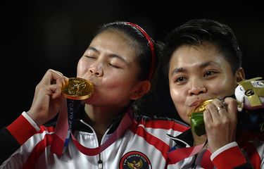 Pasangan ganda putri Indonesia Greysia Polii dan Apriyani Rahayu (kanan) berpose dengan medali emas bulu tangkis ganda putri pada upacara Olimpiade Tokyo 2020 di Musashino Forest Sports Plaza di Tokyo pada 2 Agustus 2021.