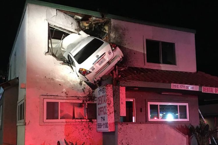Sebuah mobil tersangkut di lantai dua sebuah gedung di Santa Ana, California setelah menghantam pembatas jalan dalam kecepatan tinggi. Pengemudi mobil selamat.