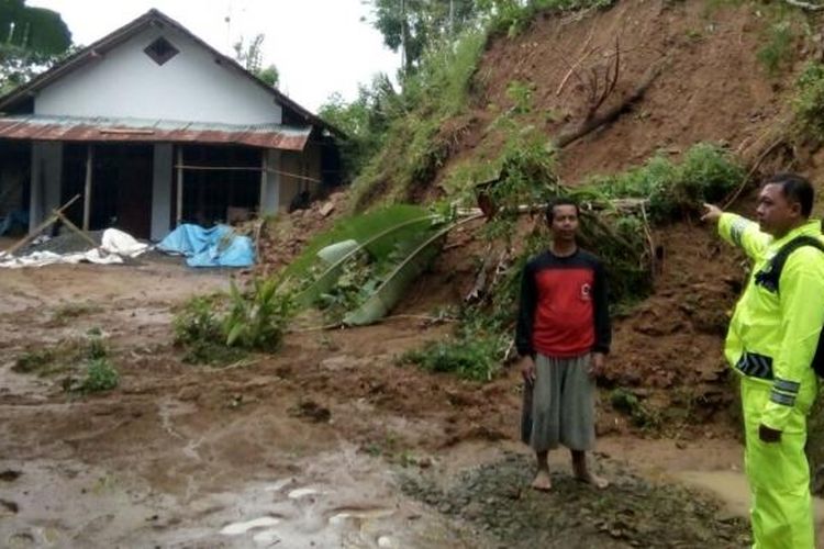 Aparat menunjuk salah satu lokasi yang diterjang longsor dan tanah retak di Desa Tumpak, Kecamatan Sawoo, Kabupaten Ponorogo, Senin ( 13/2/2017). 