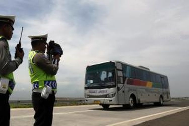Petugas dari Kepolisian Daerah Jawa Barat (Polda Jabar) menggunakan alat pendeteksi laju kendaraan (speed gun) di ruas tol Cikampek-Palimanan KM.165 arah Palimanan, di Majalengka, Senin (14/12). 