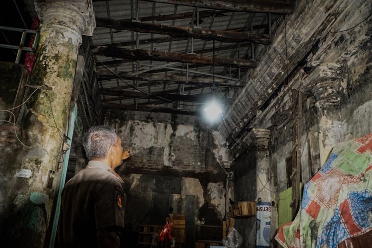 Warga saat menunjukan salah satu atap Gedung Setan Surabaya yang jebol, Rabu (18/12/2024).