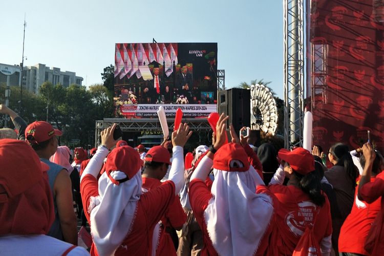 Relawan Joko Widodo-Maruf Amin bertepuk tangan dan bersorak sorai saat menonton bareng (nobar) pelantikan Jokowi-Maruf lewat layar besar di kawasan Monas, Jakarta Pusat, Minggu (20/10/2019).