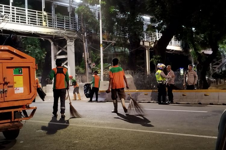 Pasukan oranye membersihkan Jalan Medan Merdeka Barat, Gambir, Jakarta Pusat usai penyampaian aksi selesai, Selasa (7/11/2023). (KOMPAS.com/XENA OLIVIA)