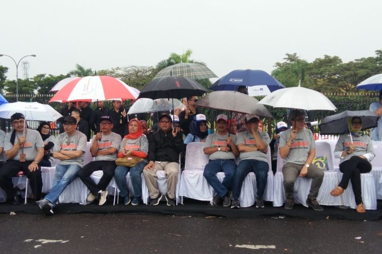 Para kontestan Pilkada Kota Bandung saat duduk berpayung dalam kegiatan kampanye damai di Lapangan Monumen Perjuangan, Kamis (15/2/2018).