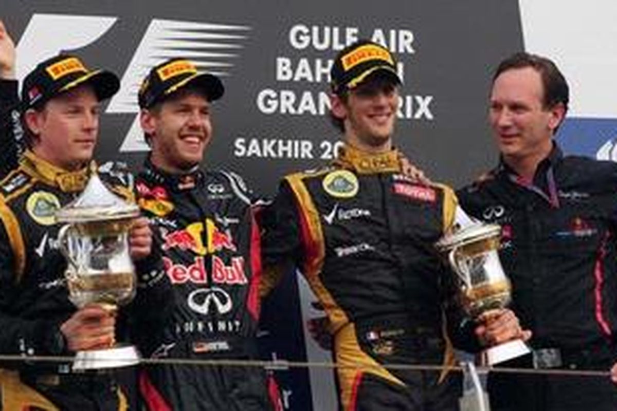 Duo Lotus, Kimi Raikkonen (kiri) dan Roman Grosjean (kedua dari kanan), mengapit pebalap Red Bull Racing, Sebastian Vettel, yang memenangi GP Bahrain, Minggu (22/4/12). Raikkonen jadi runner-up dan Grosjean di urutan ketiga.