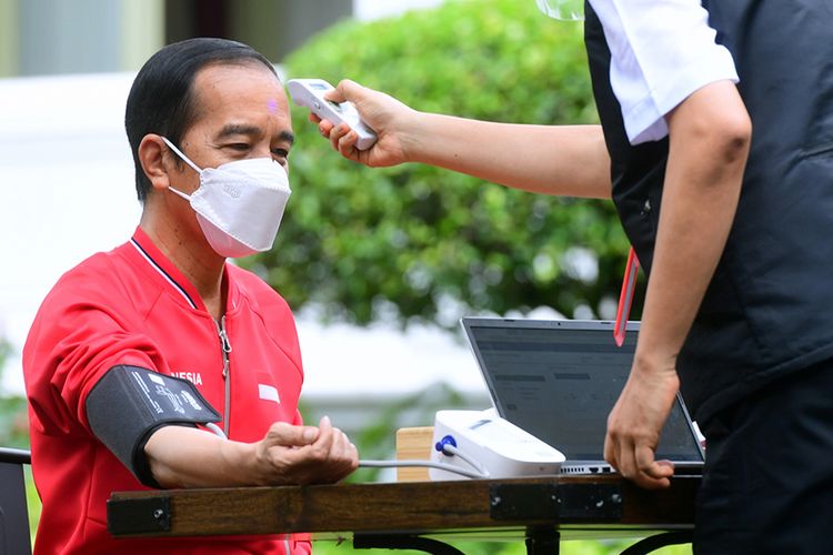 Petugas mengecek suhu tubuh Presiden Joko Widodo (kiri) sebelum disuntik dosis kedua vaksin Covid-19 produksi Sinovac di halaman tengah Istana Merdeka, Jakarta, Rabu (27/1/2021). Penyuntikan dosis kedua vaksin Covid-19 ke Presiden Joko Widodo tersebut sebagai lanjutan vaksinasi tahap pertama 13 Januari 2021 .
