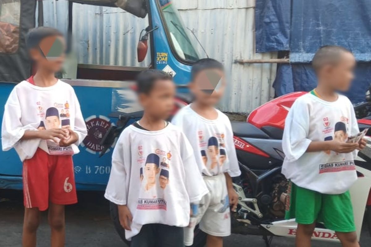 Anak-anak mengenakan kaos bergambar wajah caleg