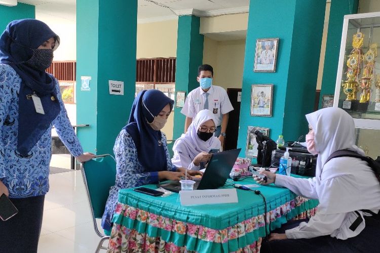 Seorang siswa berkonsultasi dengan pihak guru SMA 2 Tegal, Jawa Tengah akibat server PPDB online eror di hari pertama, Rabu (17/6/2020)