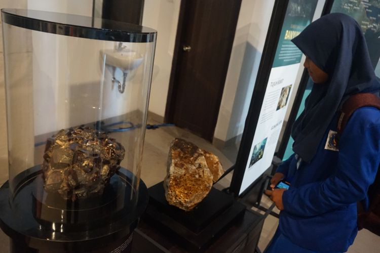 Seorang siswa sedang melihat bebatuan mengandung emas di pameran geologi Bandung di hotel Santika Banyuwangi Kamis (5/4/2018)
