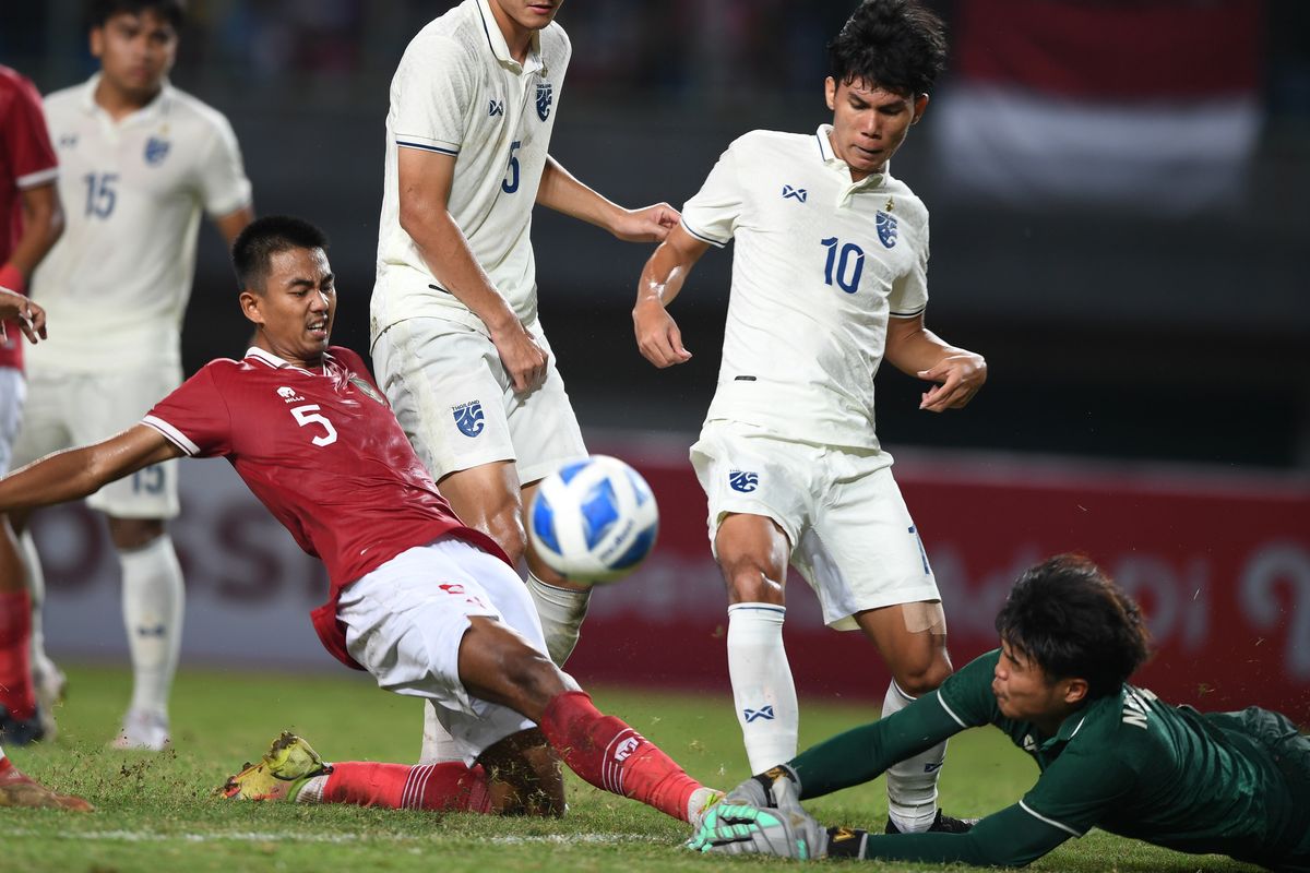 Pesepak bola Indonesia U19 Kakang Rudianto (kiri) mencoba merebut bola mendahului kiper Thailand U19 Narongsak Naengwongsa (kanan)  dalam laga penyisihan grup Piala AFF U19 di Stadion Patriot Candrabhaga, Bekasi, Jawa Barat, Rabu (6/7/2022). ANTARA FOTO/Akbar Nugroho Gumay/foc.