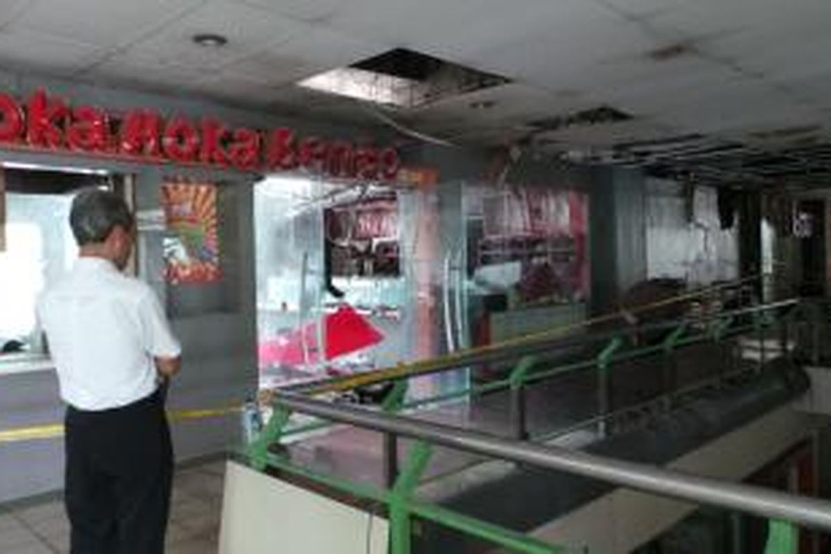 Sebuah garis polisi melintang di depan restoran cepat saji, Hoka-Hoka Bento, Stasiun Gambir, Jakarta Pusat, Jumat (27/12/2013). Untuk diketahui Hoka-Hoka Bento kebakaran dan sebanyak 19 mobil pemadam kebakaran dikerahkan.
