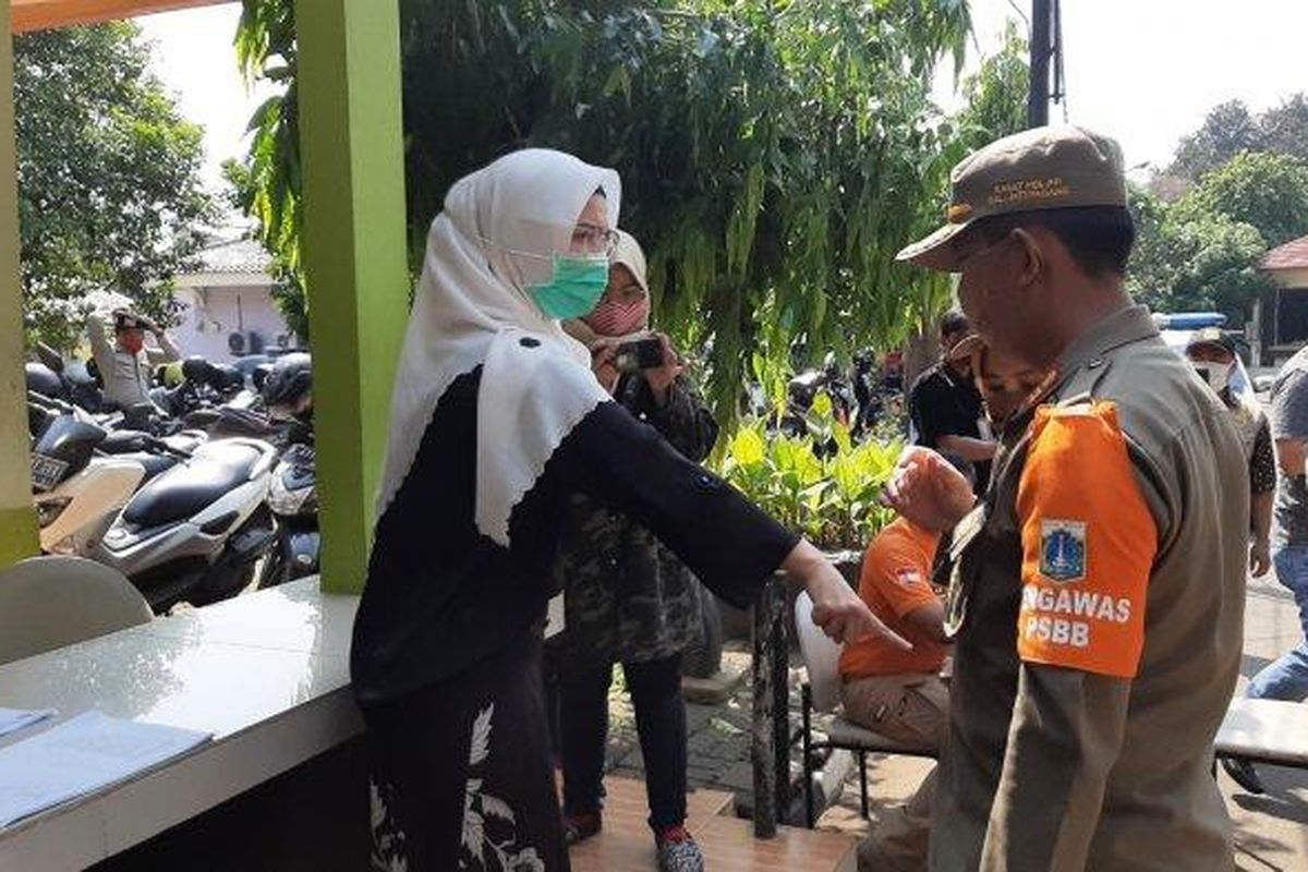 Seorang wanita yang terjaring razia masker di kawasan Pasar Minggu, Jakarta Selatan, Kamis (17/9/2020).