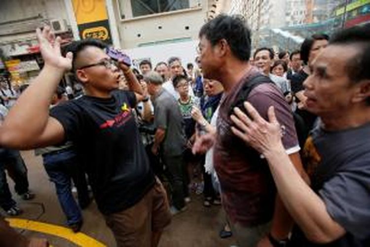Seorang aktivis pro-demokrasi (kiri) berdebat dengan seorang warga yang marah dan mencoba memindahkan barikade yang menghalangi jalanan di kawasan Causeway, Hongkong, Jumat (3/10/2014). Sebagian warga menganggap aksi unjuk rasa yang sudah berlangsung sepekan itu merugikan kehidupan mereka sehari-hari.