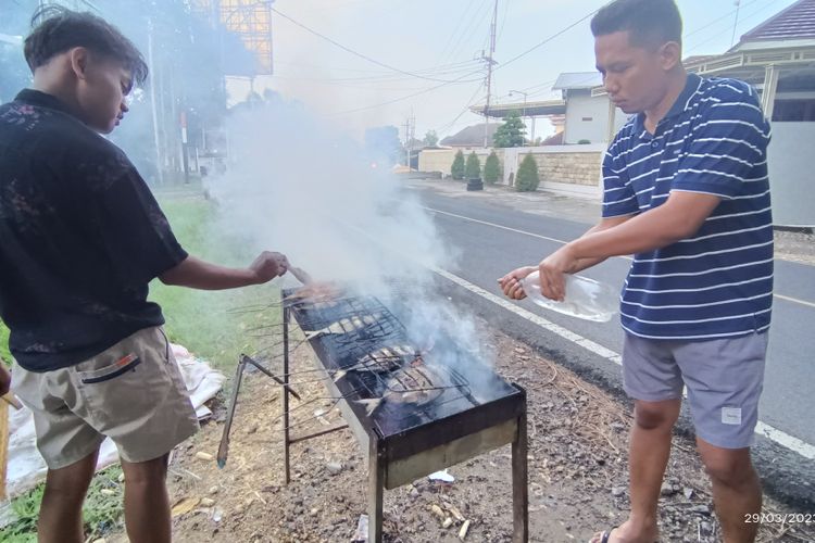 Pedagang ikan asap sedang memasak pesanan warga. Ikan asap menjadi menu favorit warga di Pamekasan untuk berbuka dan sahur selama Ramadhan.