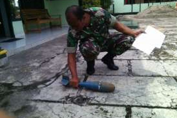 Anggota TNI menunjukkan mortir warna biru yang diserahkan pengusa besi tua kepada Koramil 0803/12 Dolopo. (dokumen Humas Kodim Madiun) 