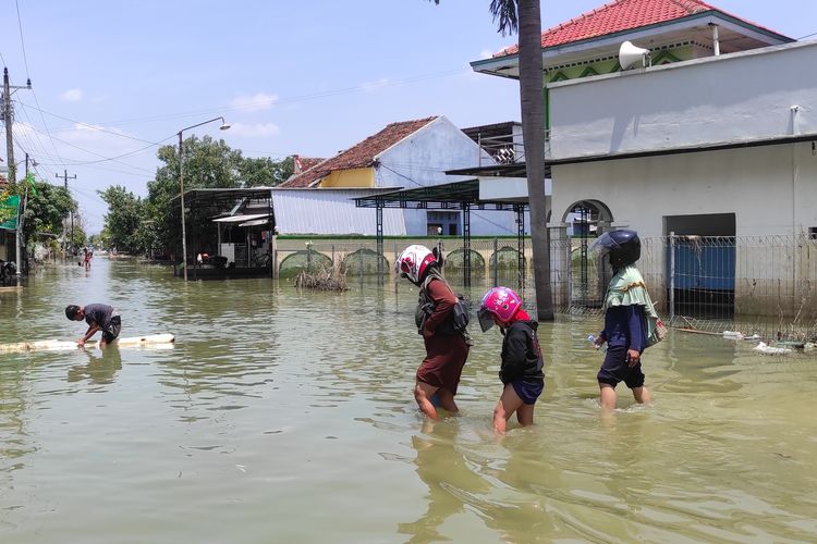 Sejumlah warga di Dukuh Kedung Banteng, Desa Wonorejo, Kecamatan Karanganyar, Kabupaten Demak nampak menerobos banjir untuk menengok rumah, Rabu (27/3/2024). 