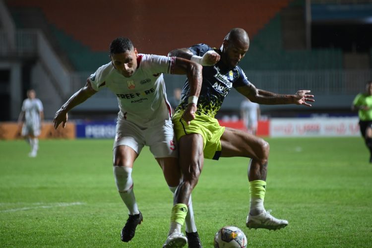 David da Silva penyerang Persib Bandung berduel dengan bek Persis Solo dalam pertandingan pekan ke-32 Liga 1 2022-2023, Selasa (4/4/2023) di Stadion Pakansari, Cibinong, Kabupaten Bogor. David da Silva mencetak brace dalam laga tersebut sehingga kembali naik ke puncak daftar top skor Liga 1 bersama penyerang Borneo FC Matheus Pato.