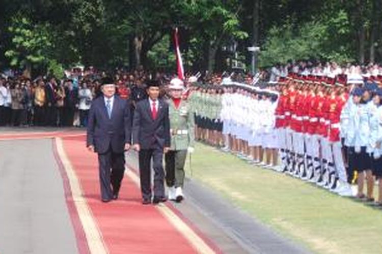 Presiden Joko Widodo (kanan) dan Presiden keenam Susilo Bambang Yudhoyono berjalan di atas karpet merah dalam upacara kemiliteran untuk melepas dan menyambut presiden di Istana Merdeka, Senin (20/10/2014).