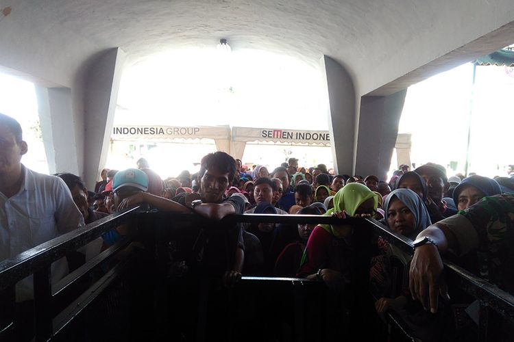Ratusan warga rela antri dan berdesak-desakan di depan pintu masuk Wisma Achmad Yani, Gresik, Jawa Timur untuk mendapatkan paket sembako murah dari PT. Semen Indonesia, Senin (11/6/2018)