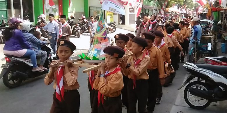 Tumpeng buku berukuran kecil saat diarak siswa MINU Trate Putra Gresik di sekitar sekolah, Senin (14/8/2017).