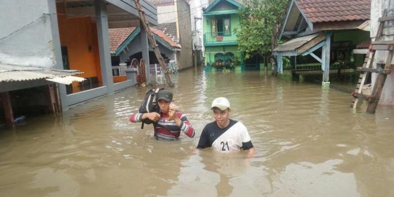 Korban banjir di Tangerang menerobos air untuk beraktivitas ke tempat lain, Senin (14/11/2016).