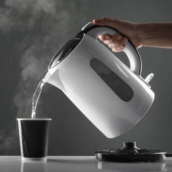 Ilustrasi menuangkan air panas dari teko listrik