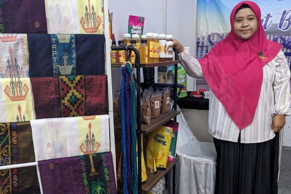 Pembina Industri Dinas Perindustrian dan Perdagangan (Disperindag) Tapanuli Tengah Riza Erliana memperlihatkan beberapa produk UMKM wilayahnya di Kodam I Bukit Barisan Expo 2023, Lapangan Benteng, Medan, Rabu (19/7/2023). () 
