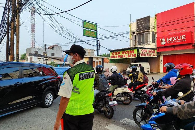 Petugas keamanan sekolah Global Islamic School (GIS) mengurai kepadatan lalu lintas di depan SD GIS, Senin (5/6/2023) pagi.