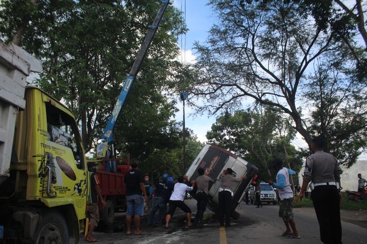 Pihak kepolisian mengevakuasi minibus yang terguling di depan Yonif 410 Blora, Kamis (2/12/2021)