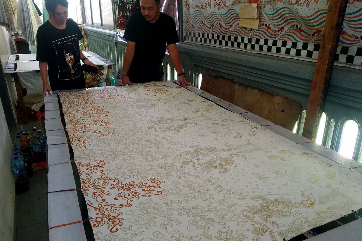 Santika dan Yogi Rosdianta, pemilik usaha Batik Mawar Putih, berpose di samping kain batik yang dipesan pebasket NBA Justin Holiday, Selasa (8/2/2022)