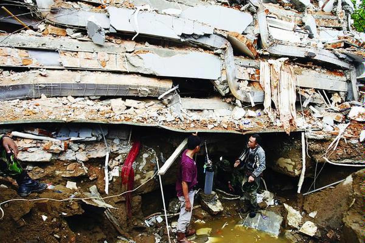 Petugas medis dan anggota TNI berusaha memberikan bantuan oksigen kepada salah seorang korban yang masih hidup tertimpa reruntuhan bangunan bertingkat lima di Jalan Belakang Tanksi, Padang, Sumatera Barat, Kamis (1/10).