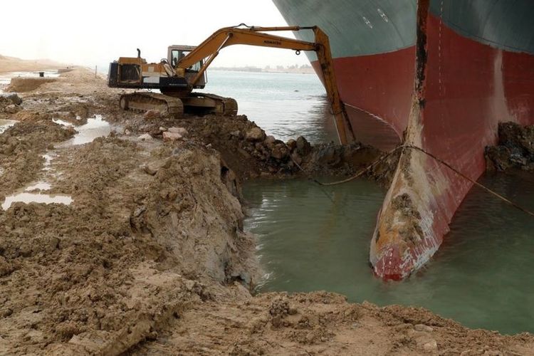 Ekskavator melakukan pengerukan untuk membebaskan kapal Ever Given yang membuat Terusan Suez macet sejak Selasa (23/3/2021).