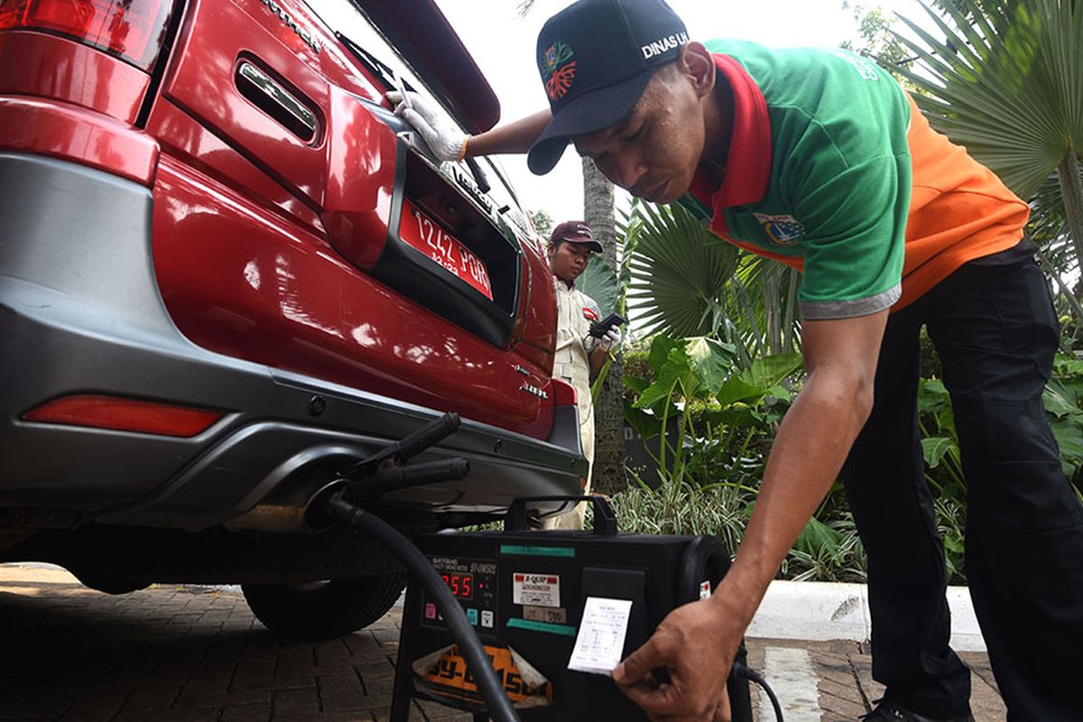 Seorang petugas Dinas Lingkungan Hidup Provinsi DKI Jakarta melakukan uji emisi kendaraan dinas saat peluncuran aplikasi e-Uji Emisi di Balai Kota DKI Jakarta, Selasa (13/8/2019). Pemprov DKI Jakarta meluncurkan aplikasi e-Uji Emisi untuk mempermudah masyarakat melakukan uji emisi kendaraan.