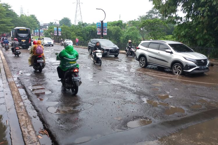 Kondisi terkini di Jalan Boulevard Grand Depok City yang berlubang hingga digenangi air hujan pada Jumat (20/5/2022).