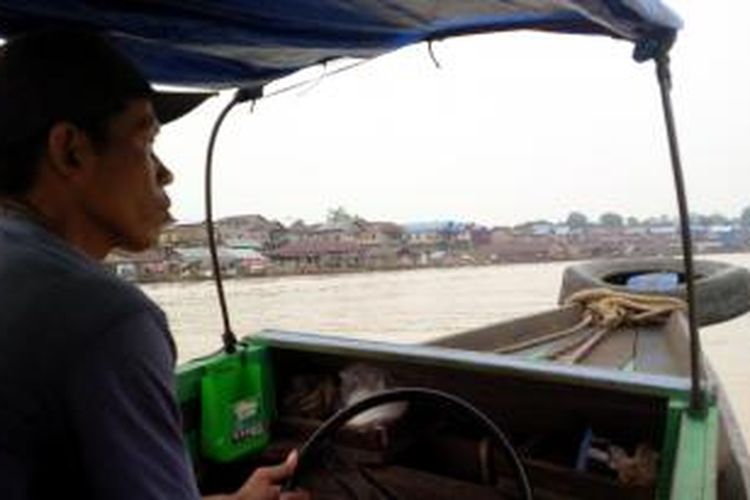 Suryani (40) saat mengemudikan perahu 