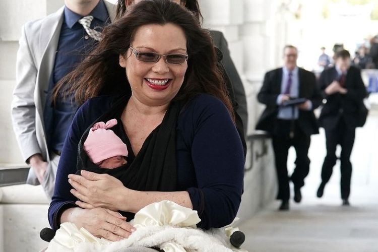 Senator Tammy Duckworth berada di Capitol Hill, Amerika Serikat dengan bayi perempuannya yang baru lahir Maile Pearl Bowlsbey, Kamis (29/4/2018). (AFP/Alex Wong)