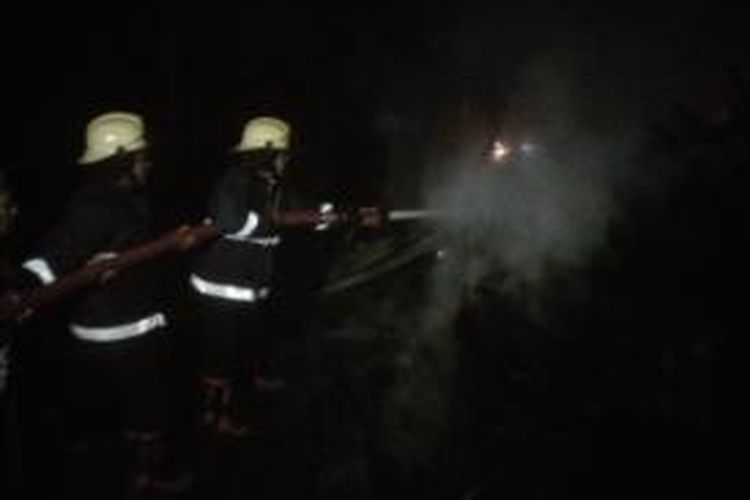 Petugas pemadam kebakaran berjibaku memadamkan api yang membakar kayu di gudang milik Suwono di Desa Kwadungan, Kecamatan Ngasem, Kabupaten Kediri, Jawa Timur, Minggu (29/9/2013).