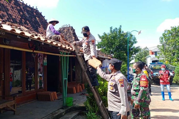 Wakapolsek Dempet Iptu Sumarno bersama warga dan Koramil Dempet bergotong royong memperbaiki atap rumah warga yang rusak akibat puting beliung yang melanda Desa Brakas Kecamatan Dempet Kabupaten Demak Jawa Tengah, Jumat (26/2/2021)