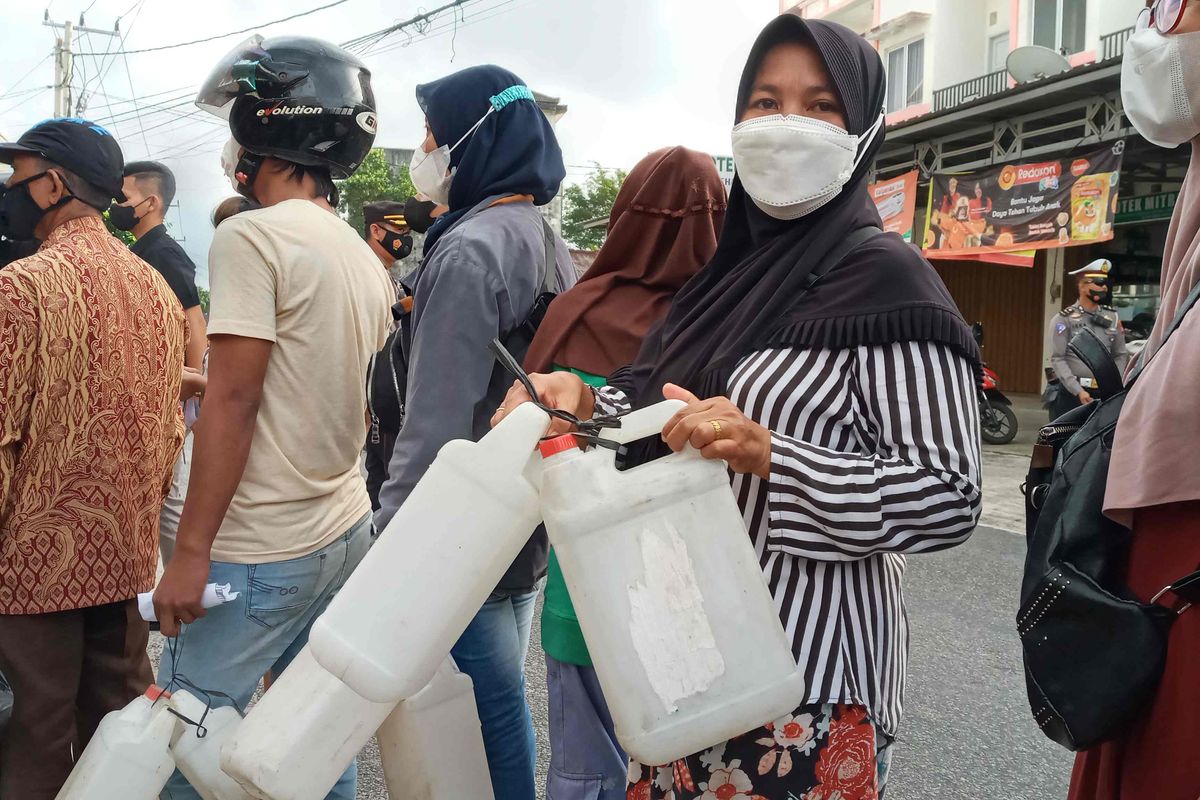 Emi (40) pembeli minyak goreng curah bersubsidi membawa jeriken saat operasi minyak goreng curah di Pasir Padi, Kota Pangkalpinang, Bangka Belitung, Jumat (8/4/2022).
