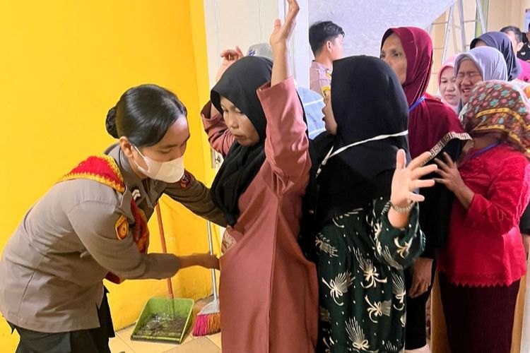 Anggota Polwan memeriksa pekerja pelipat surat suara sebelum memasuki gedung logistik di Kantor KPU Kabupaten Pelalawan, Riau, Rabu (17/1/2024).