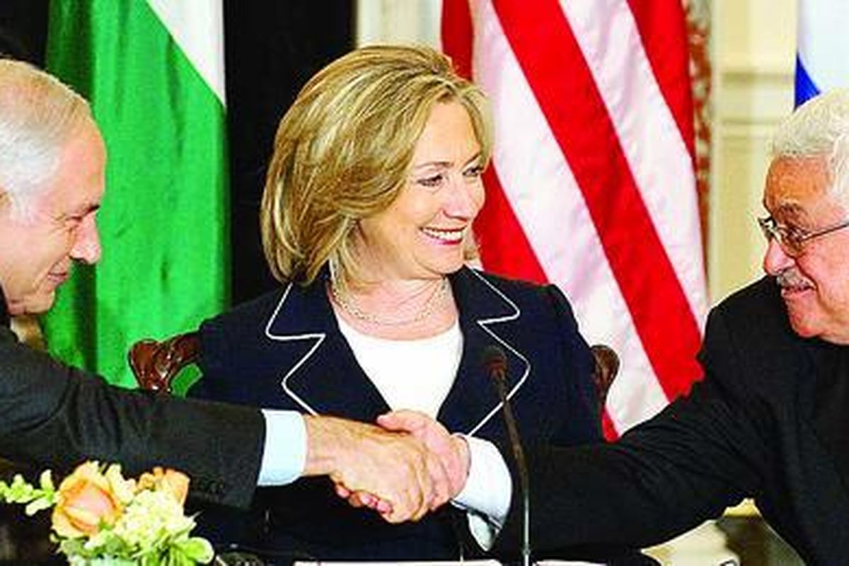 Presiden Palestina Mahmoud Abbas (kanan) dan Perdana Menteri Israel Benjamin Netanyahu (kiri) berjabat tangan disaksikan Menlu AS Hillary Clinton saat dilangsungkannya perundingan perdamaian di Departemen Luar Negeri AS di Washington DC, Kamis (2/9).