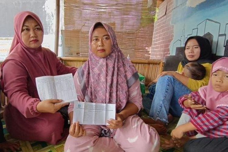 Sejumlah ibu-ibu di Pangandaran memperlihatkan tulisan uang tabungan anaknya yang belum dikembalikan pihak sekolah dalam pertemuan di samping SD Negeri 2 Kondangjajar di Kecamatan Cijulang, Kabupaten Pangandaran, Sabtu (17/6/2023).