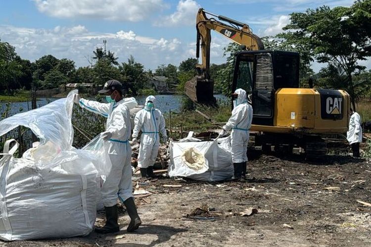Petugas sedang mengangkut material yang terpapar zat radioaktif untuk di bawa ke tempat penyimpanan sementara di gudang PT PMT, Kawasan Industri Cikande, Modern.