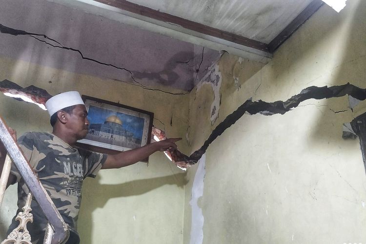 Pemilik rumah menunjukkan retakan pada dinding yang rusak akibat bencana gerakan tanah di Kampung Nyalindung, Des Pasirsuren, Kecamatan Palabuhanratu, Sukabumi, Jawa Barat, Sabtu (5/3/2022).